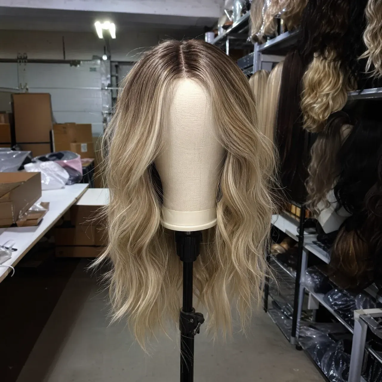 Source product photo of a blonde wig on a mannequin in storage.